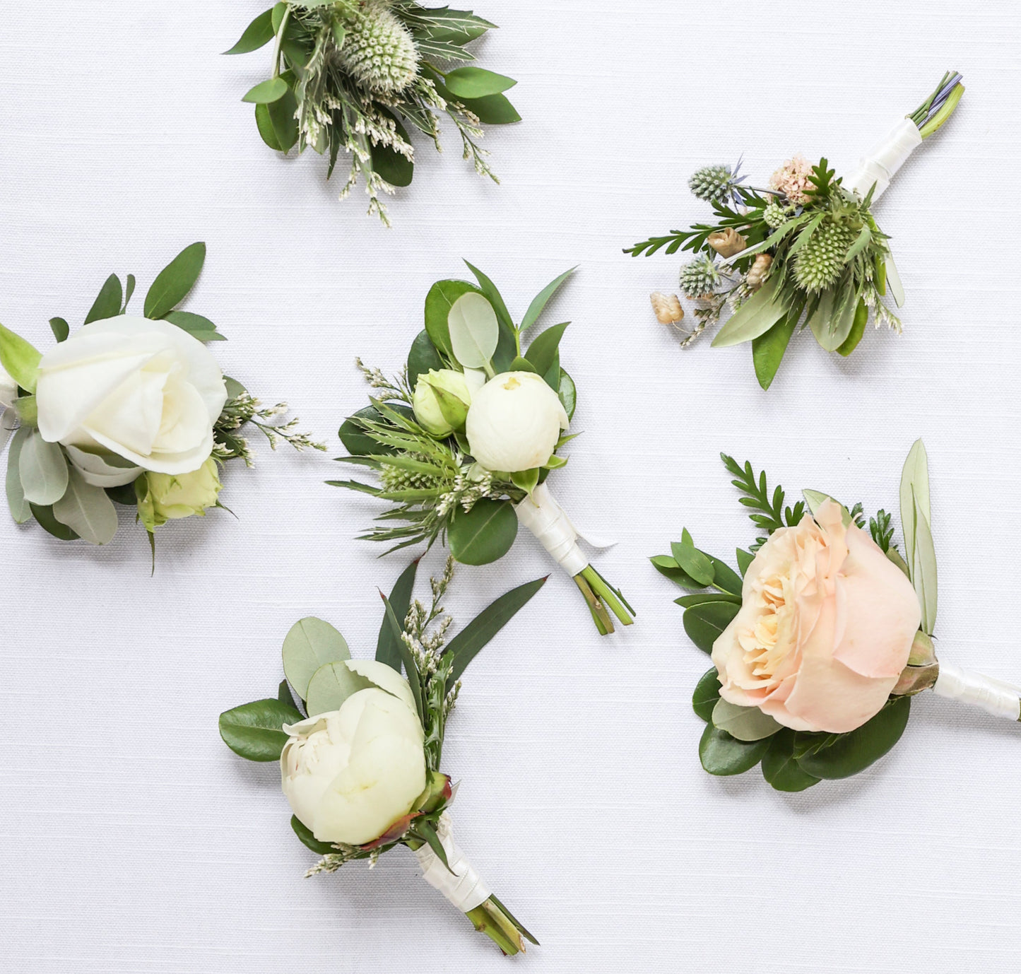 Set of floral buttonholes on a white background