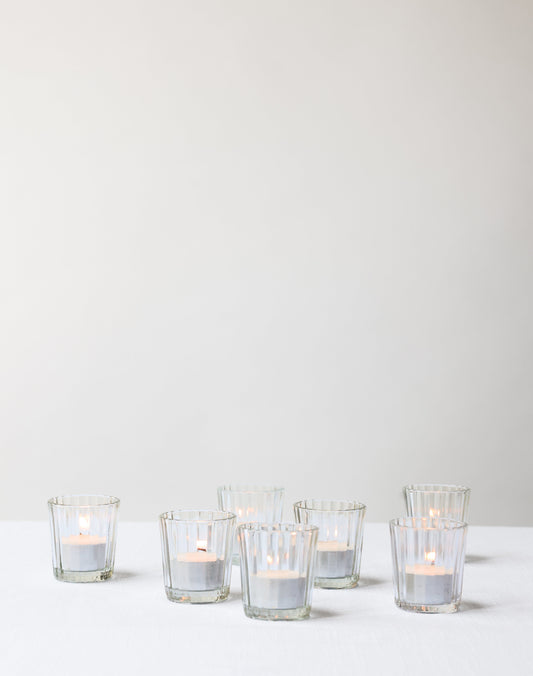 Small glass candle holder with candle shown in a group.